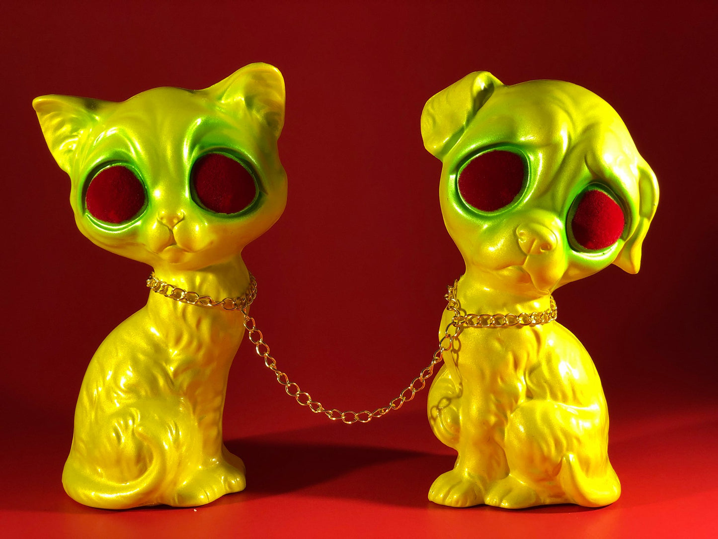 Sad dog, Sad cat chained together. Yellow and green with red flocked eyes